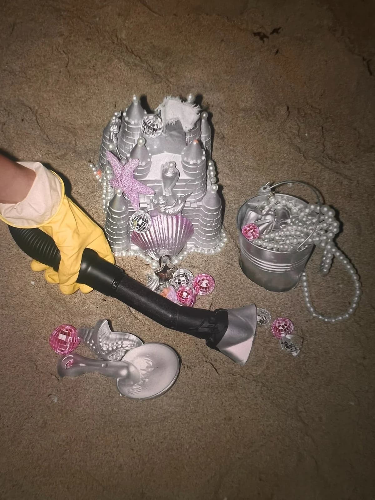 Cleaning the sand around a silver castle and a bucket of pearls
