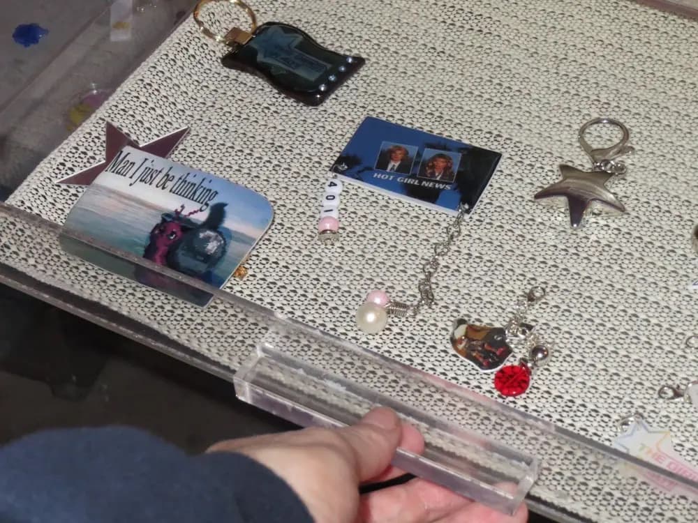 An open collection drawer with star keychains, photo charms, and a pearl necklace