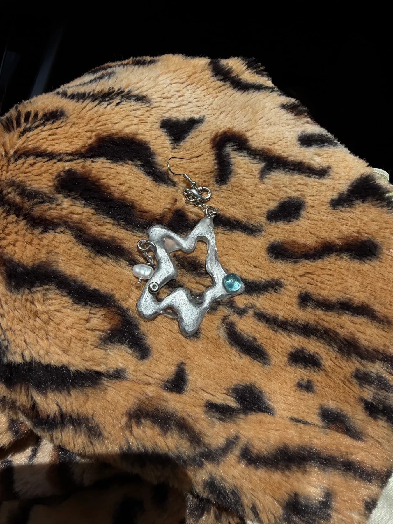 Silver star earring on leopard print